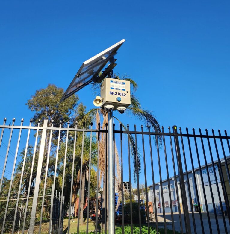 Solar-powered secWatch unit MCU032 with twin cameras and speaker, mounted on a pole at a fenced site